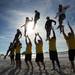 Michigan cheerleaders fly through the air as they come down from a pose while practicing on the beach in Clearwater, Fla. on Sunday, Dec. 30. Melanie Maxwell I AnnArbor.com